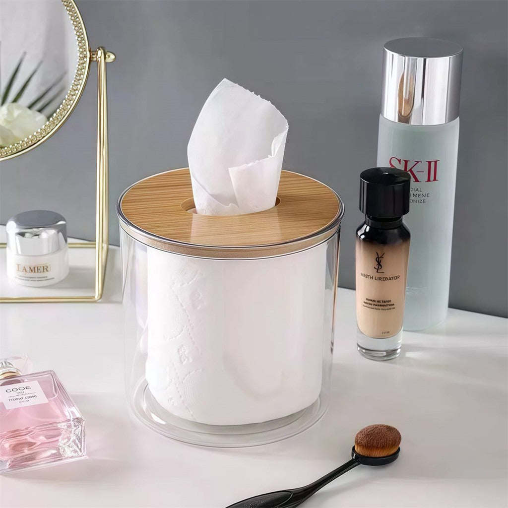 Porta papel higiênico transparente com tampa de bambu usado como dispenser de lenços em penteadeira com cosméticos.