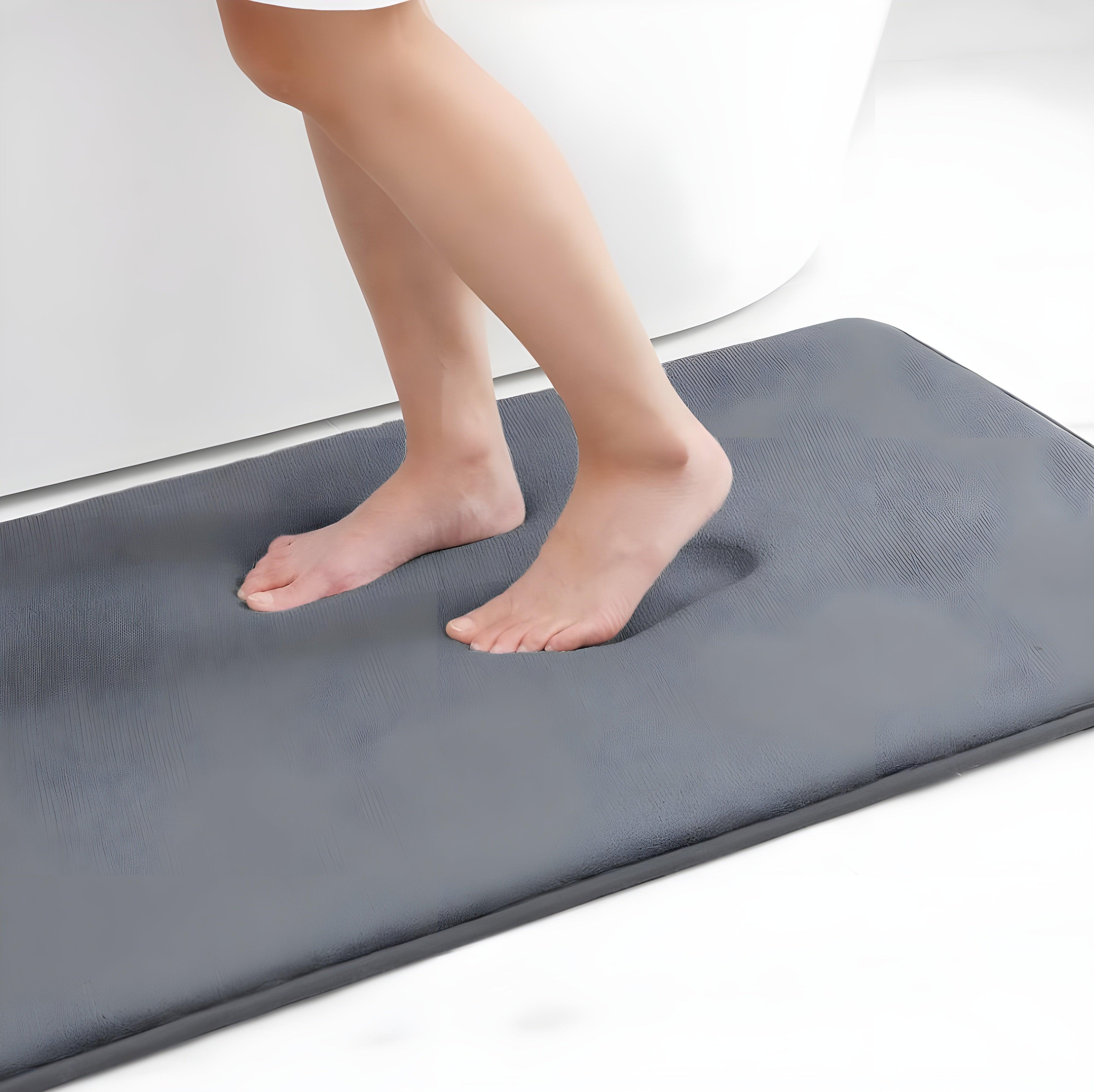 Tapete Soft cinza claro com pés sobrepostos, textura macia e absorvente.